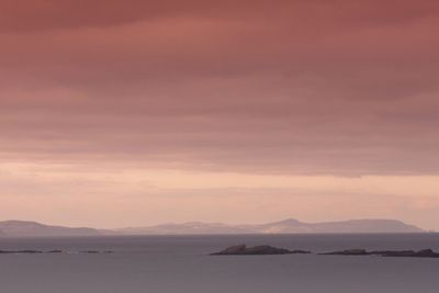 Scenic view of sea and mountains against sky