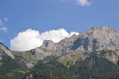 Rocky mountain peak against cloudy sky