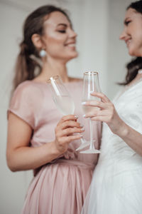 Bridesmaid and bride holding champagne flute