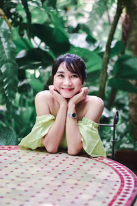 Portrait of a smiling girl sitting on plant