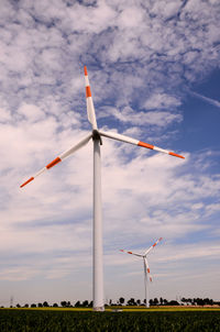 Low angle view of windmill on field against sky