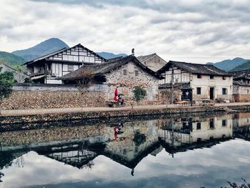 Reflection of buildings on lake against sky