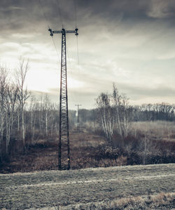 Electricity pylon on field against sky