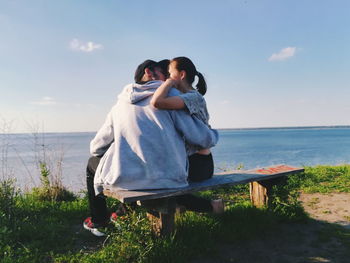 Couple kissing while sitting at beach