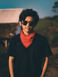 Portrait of young man wearing sunglasses standing outdoors