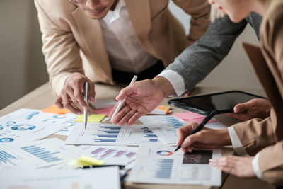 Midsection of business colleagues working on table