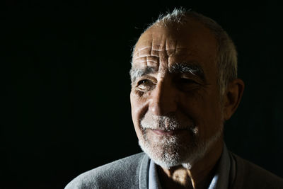 Portrait of man against black background