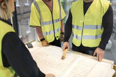 Workers reviewing blueprint at construction site