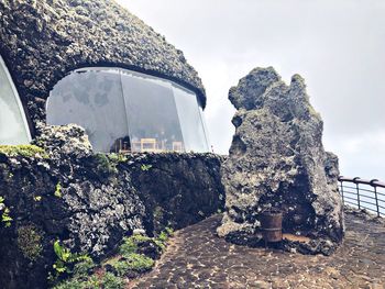 Rock formation in building against sky