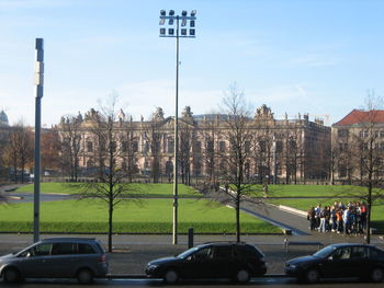 Cars on grass against sky