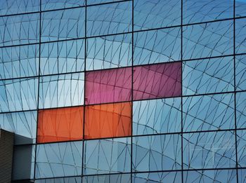 Low angle view of glass building against sky