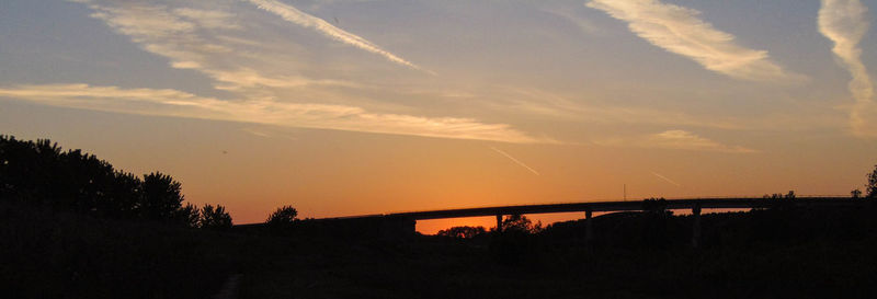 Silhouette bridge against sky during sunset