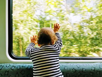 Rear view of a girl on vehicle window