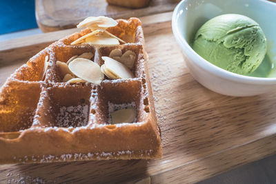 Close-up of waffle with green tea ice cream in bowl on table