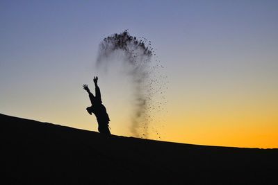 Silhouette person against clear sky during sunset