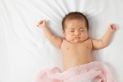 Cute baby girl lying on bed