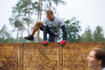 Low angle view of man looking away against trees