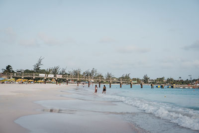 Women at beach against sky