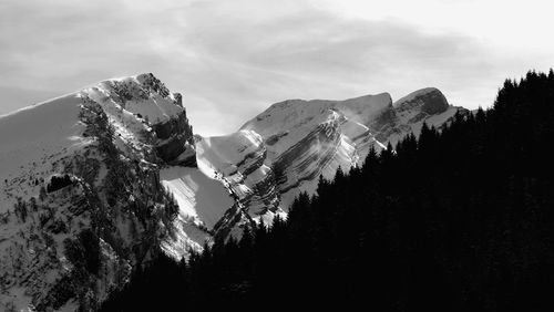 Low angle view of snowcapped mountains against sky