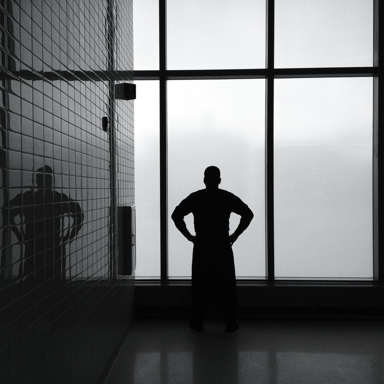 indoors, window, silhouette, glass - material, lifestyles, transparent, standing, full length, men, rear view, looking through window, leisure activity, architecture, built structure, person, home interior, side view, reflection