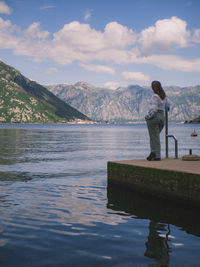 Rear view of man standing by lake