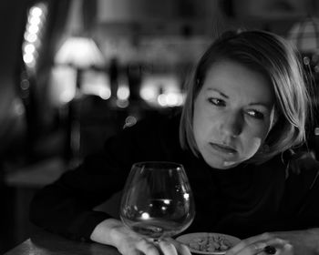 Thoughtful mid adult sitting by food and drink on table in restaurant