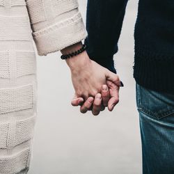 Midsection of couple holding hands