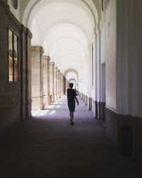 Rear view of man walking in corridor