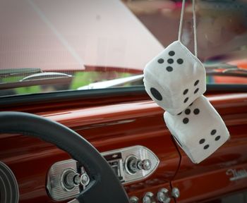 Close-up of dice hanging in car