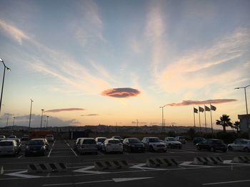 Cars on road against sky during sunset