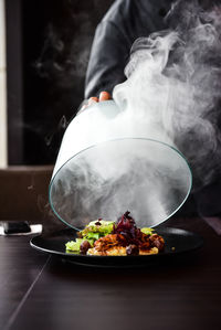 Midsection of man serving food on table