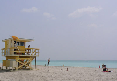 People at beach against sky