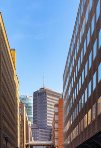 Low angle view of modern buildings against clear blue sky