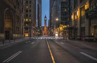 Road leading towards old city hall clock tower at dusk