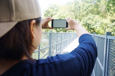 Cropped image of woman photographing with mobile phone