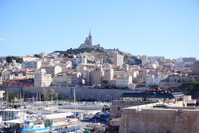 Buildings in city against clear blue sky