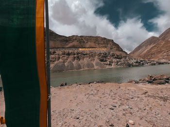 Scenic view of lake by mountains against sky