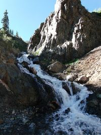 Scenic view of waterfall against sky