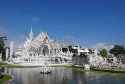 Fountain in front of temple against sky