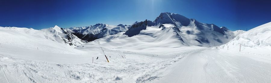 Scenic view of snowcapped mountains against clear blue sky