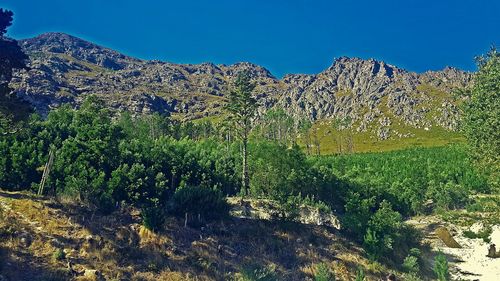 Scenic view of mountains against clear blue sky