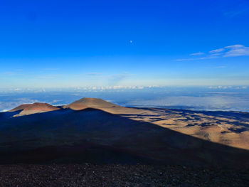 Scenic view of volcanic landscape against blue sky