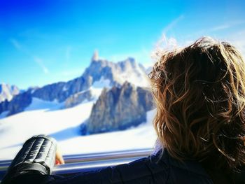 Rear view of woman looking at snowcapped mont blanc from ski lift