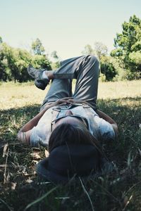 Rear view of woman sitting on field