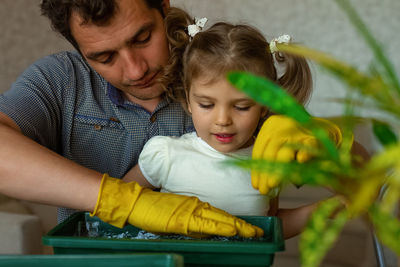 Father teaching gardening to daughter