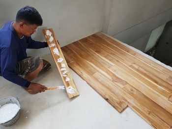 High angle view of carpenter making wooden floor