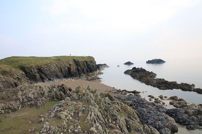 Rocks on beach against sky