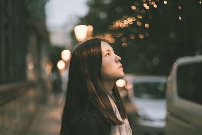 Side view of young woman in car