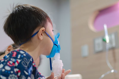 Boy wearing oxygen mask in hospital