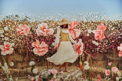 Full length of teenager girl standing on field against sky